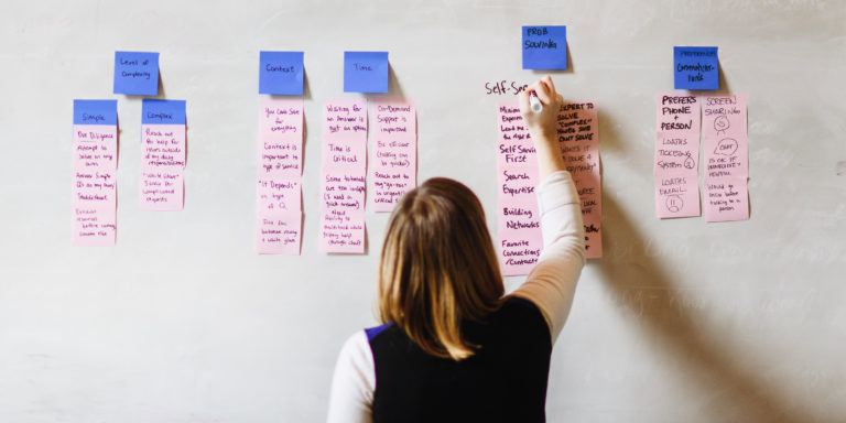 woman at whiteboard writing with marker