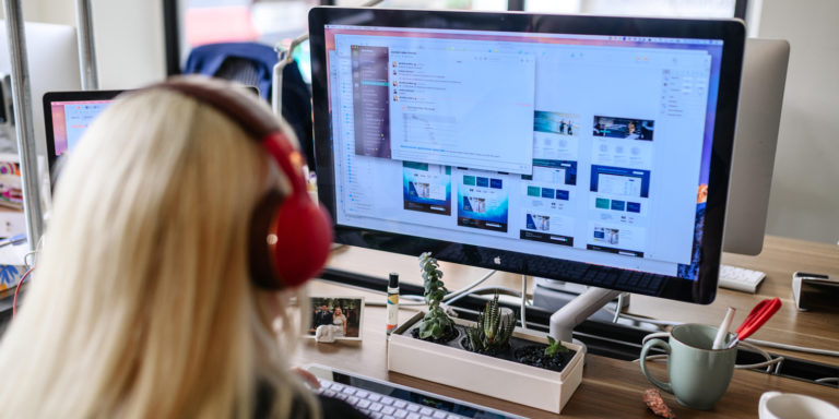 Woman looking at a computer with many designs on the screen