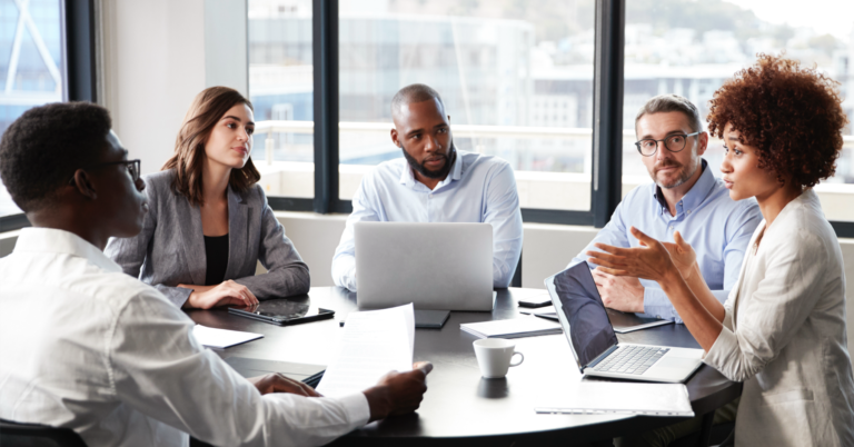 Group of business professionals having a conversation around a conference table