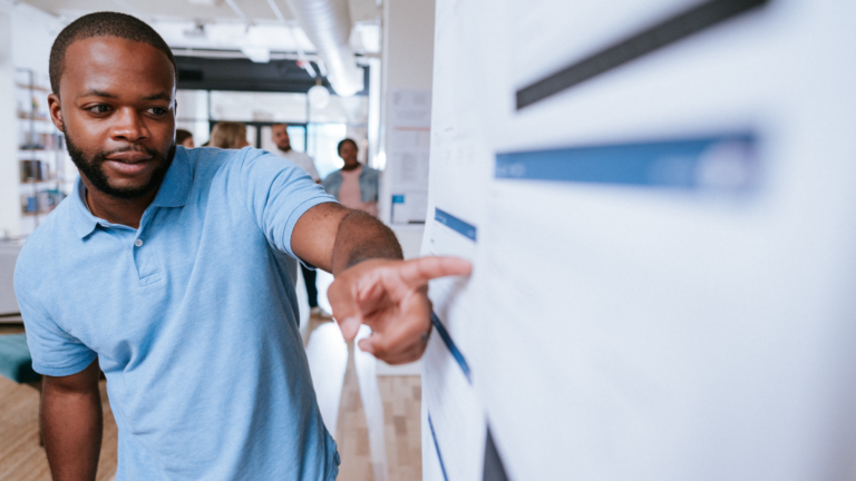 Person pointing at a data point on a poster