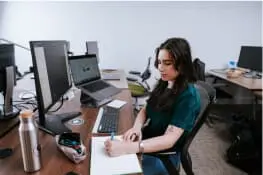 A person sitting at a computer and drawing wireframes