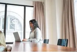 Thinker typing at conference table